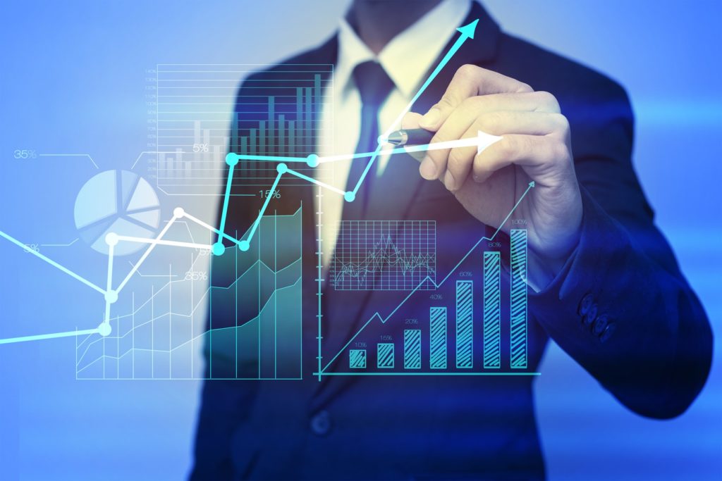 Business man plotting point on a graph and charts showing growth