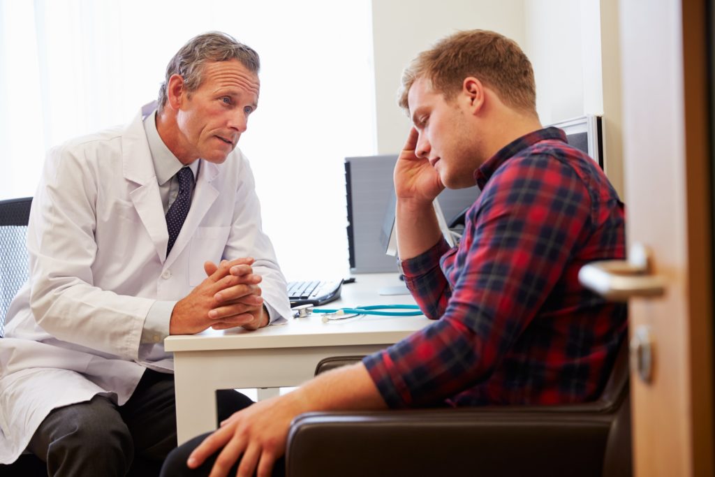 Doctor talking with younger male patient