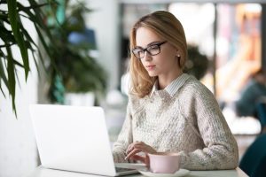 Clinician using a laptop to write a progress note