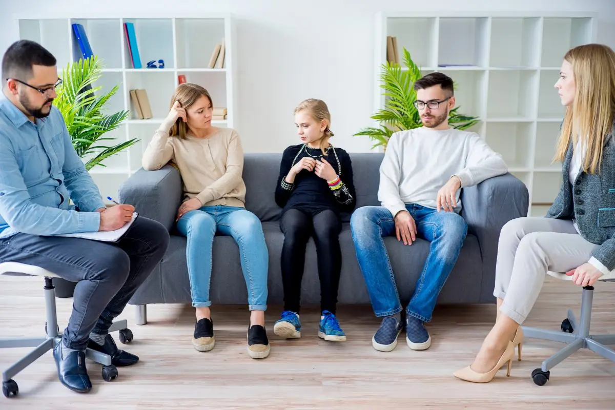 Family therapist documenting a session with parents and child using mental health charting and documentation software