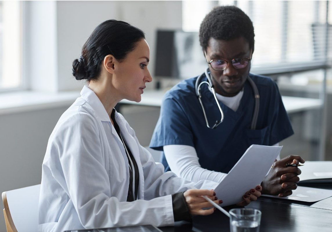 A psychiatrist reviewing a mental health clinical summary with a colleague
