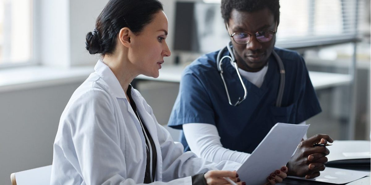 A psychiatrist reviewing a mental health clinical summary with a colleague