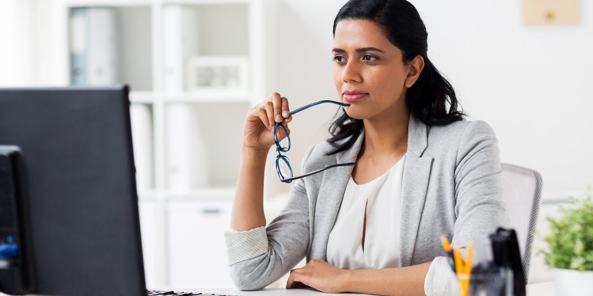 Behavioral health professional reviewing electronic health record options on computer, comparing EHR and EMR systems for practice management and care coordination.