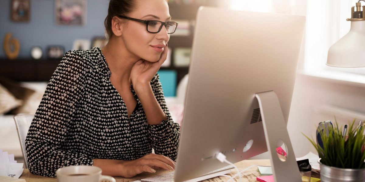 Counselor using treatment planning software on computer to track client outcomes and therapy progress measures, demonstrating measurement-based care in behavioral health.